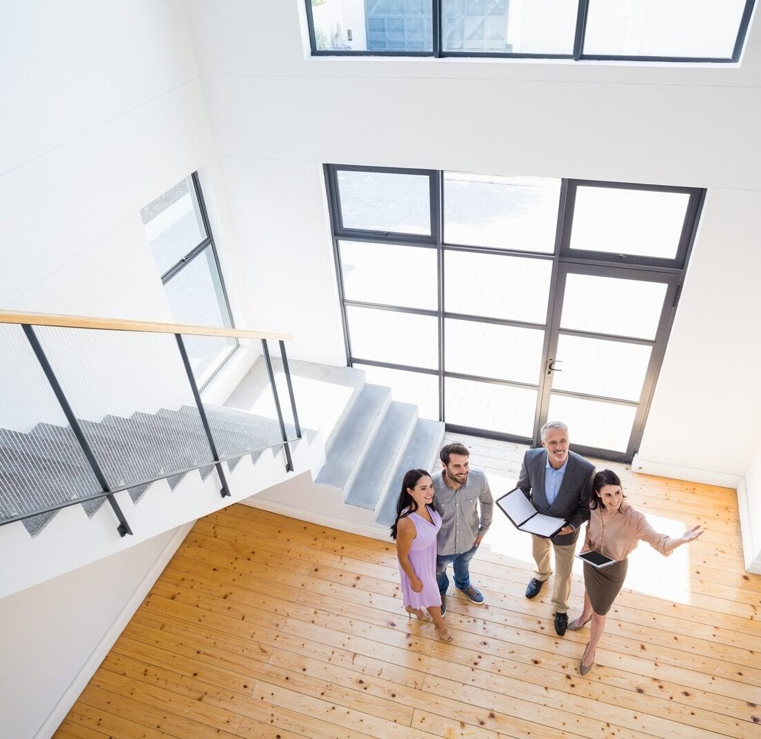 Real estate agent walking a family through a bright, newly purchased home