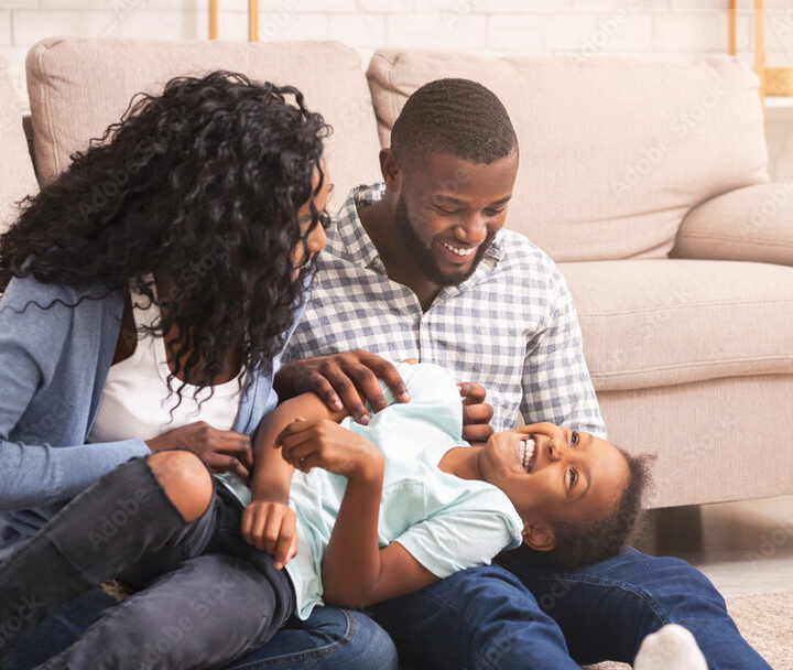 Parents cuddling with their baby at home